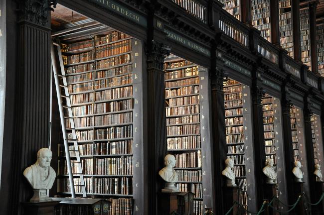 A large library with a row of historical figures